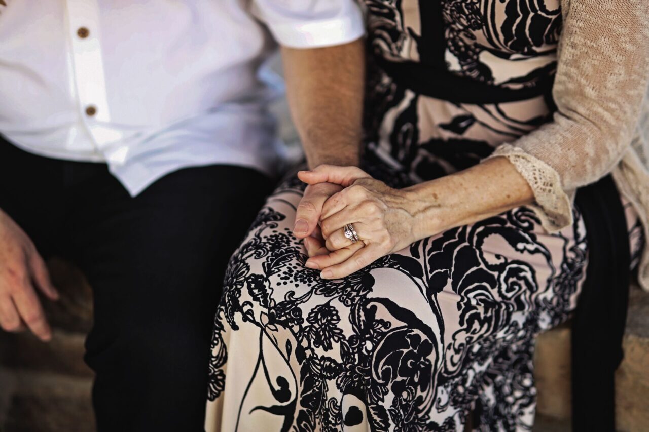 High angle closeup shot of a couple holding hands showing their engagement ring